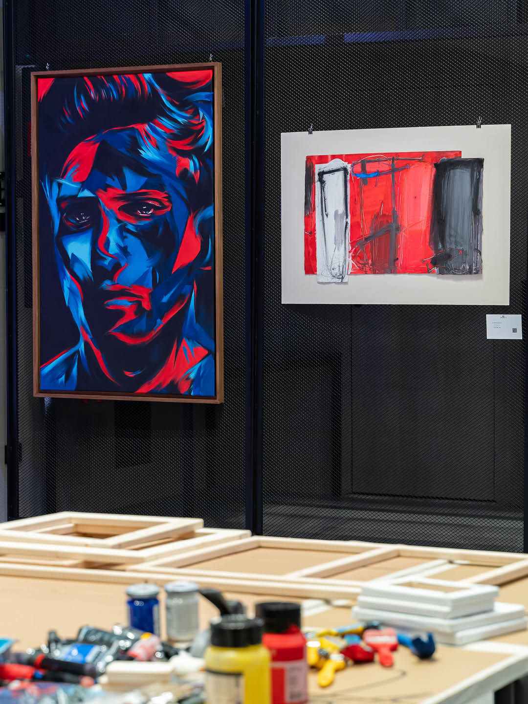 Contemporary artworks by Guido DutyGorn and Enzo Esposito displayed side by side, featuring a blue and red portrait and an abstract red and black composition.