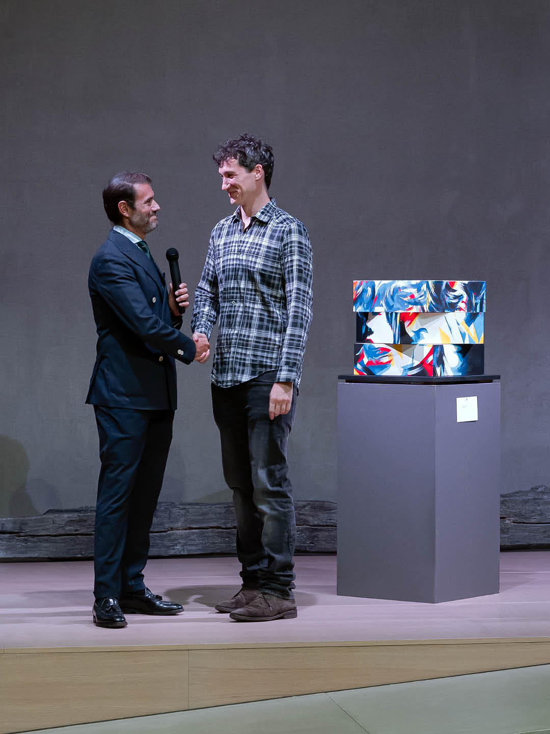 DutyGorn meeting Andrea Orsini Scataglini of Kruso Art during the Momentum exhibition in Milan, standing beside a colorful contemporary artwork.