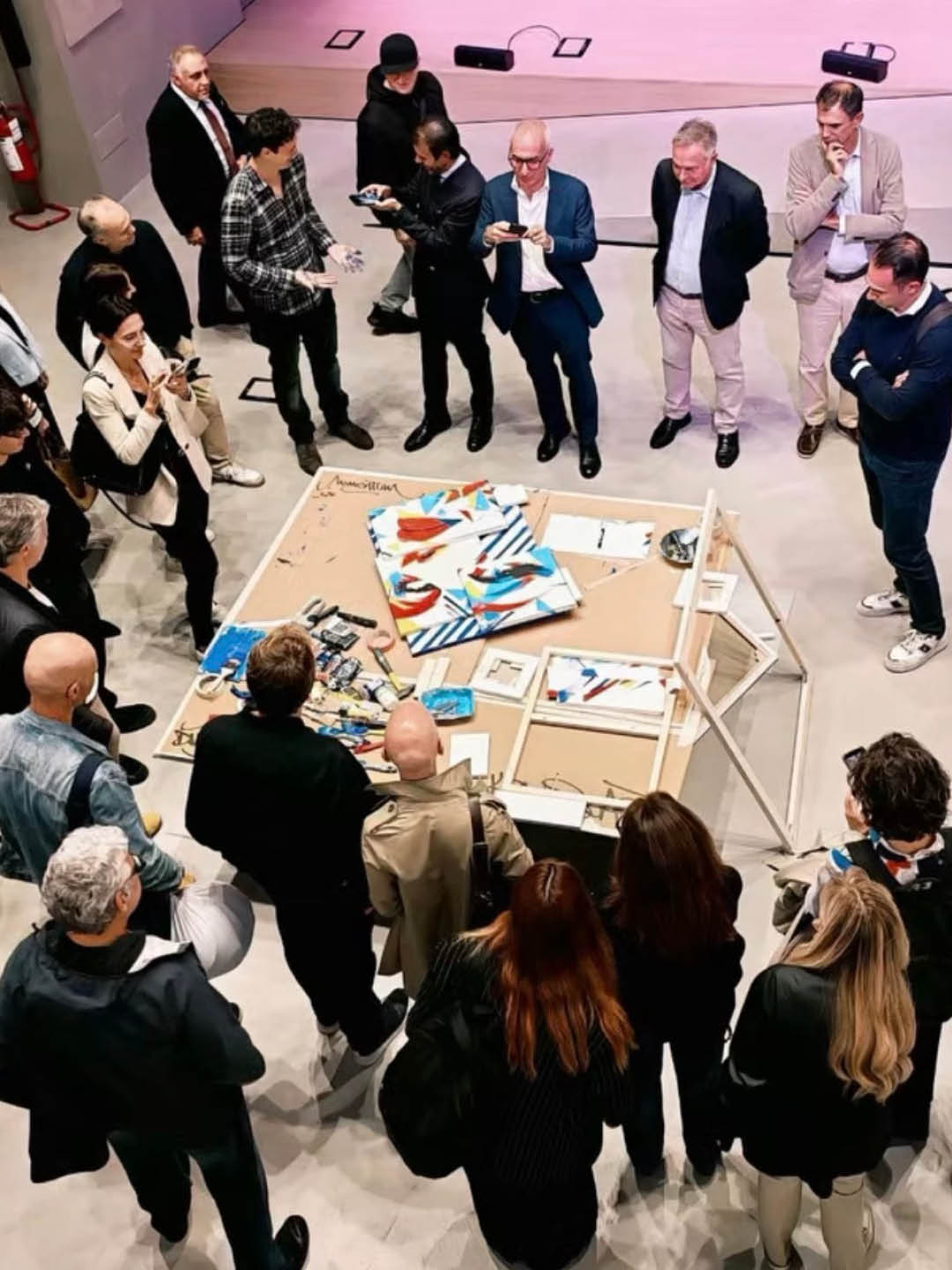 DutyGorn performing live in front of an audience, surrounded by painted canvas panels during the deconstruction and reconstruction of a contemporary artwork.
